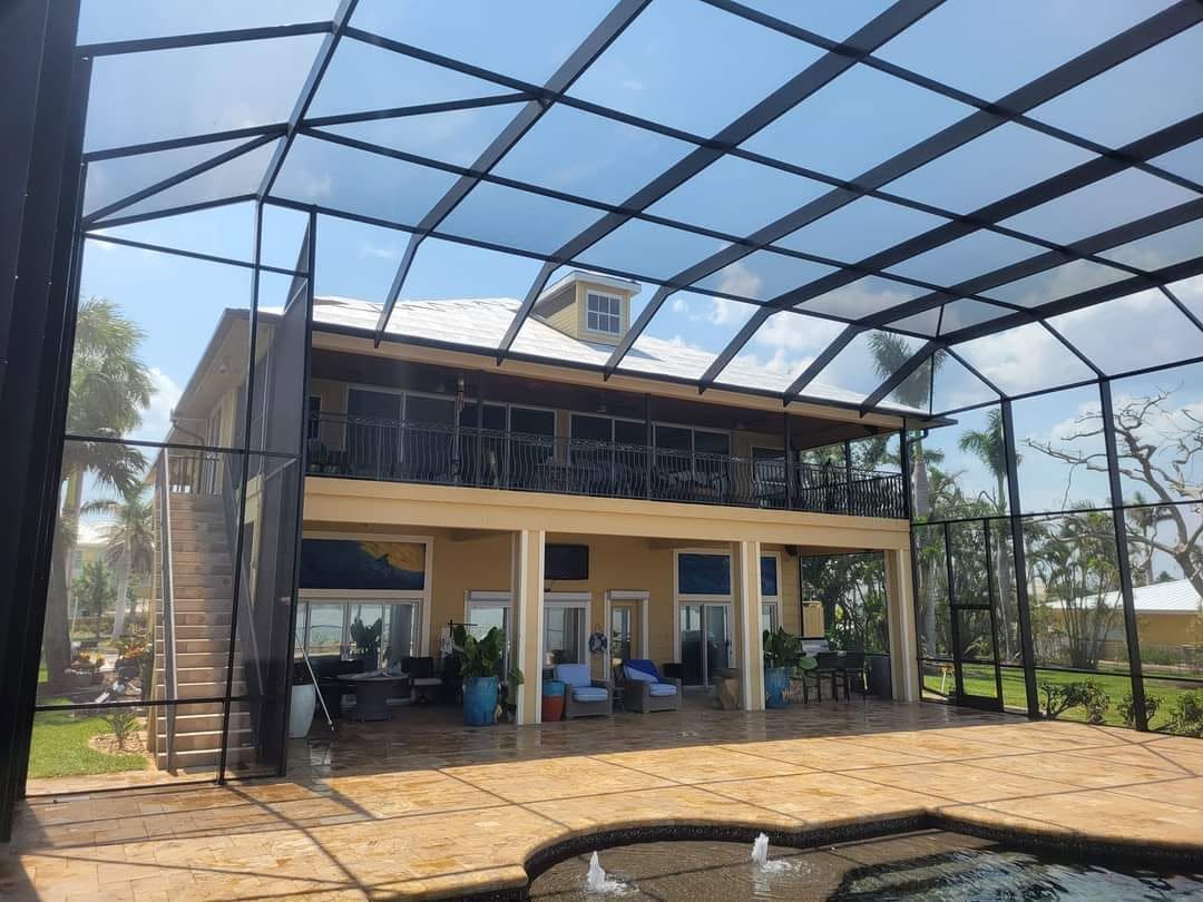 Two-story panoramic pool enclosure over a paver deck
