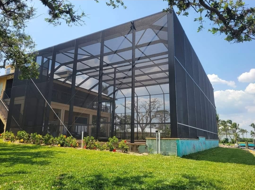 Tall two-story birdcage enclosure viewed from the lawn
